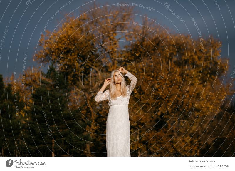 Beautiful blonde woman gazing at autumn countryside inspiration tender beautiful lace content woodland smile contemplation rural orange foliage young adult joy