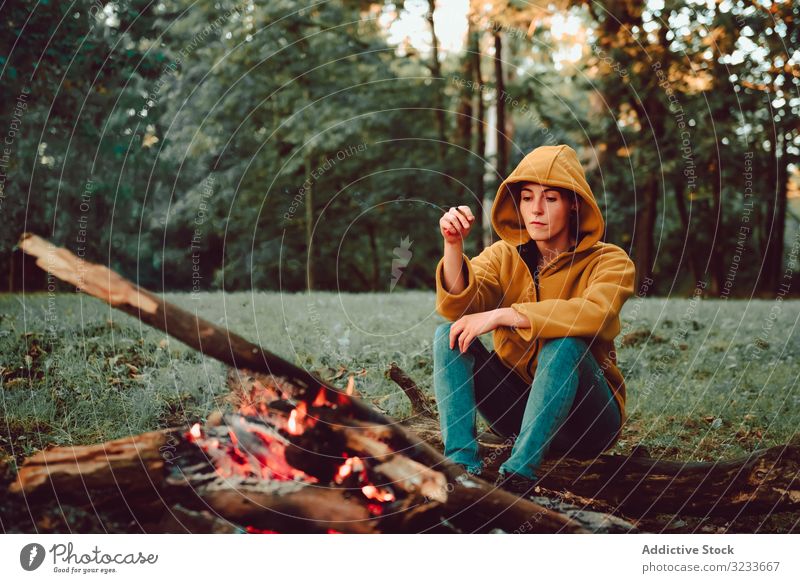 Traveling woman warming hands near campfire on forest glade tranquil flame contemplate relax solitude calm quiet silence firewood freedom enjoy serenity