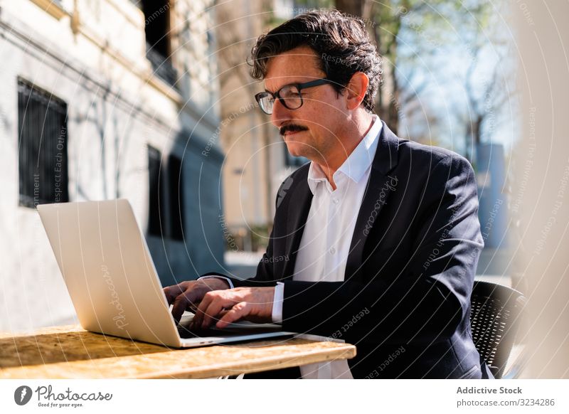 Elderly man using gadget while relaxing at cafe tablet digital smart browsing watching male elderly aged senior device working connection lifestyle professional