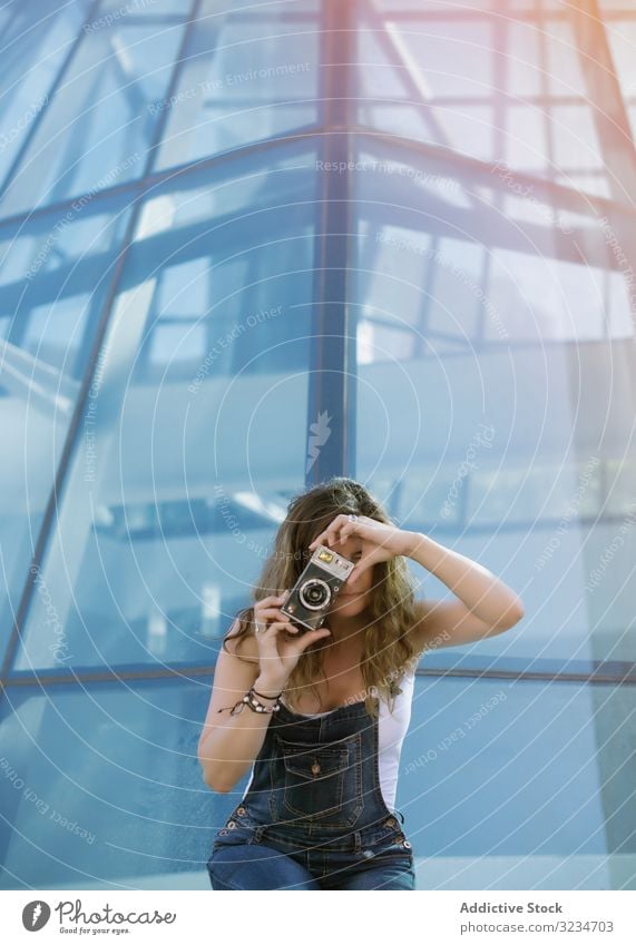 Creative woman taking photo on camera in sunny day enthusiastic creative architecture geometric picture female tourist young city smart tourism vacation