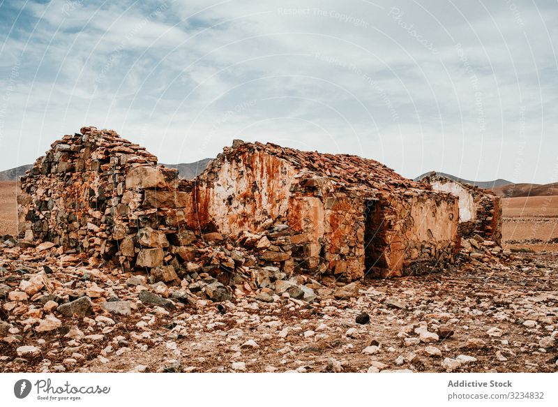 Dilapidated old buildings in mountain desert under cloudy sky house dilapidated ancient architecture stone shabby structure entrance amazing rustic exterior