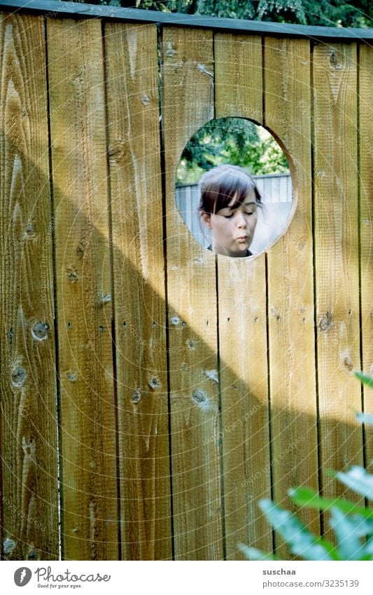 board wall with hole Wooden wall Wooden fence Hoarding Hollow Head feminine Girl Young woman Vista whistle whistle a song Happiness Downward