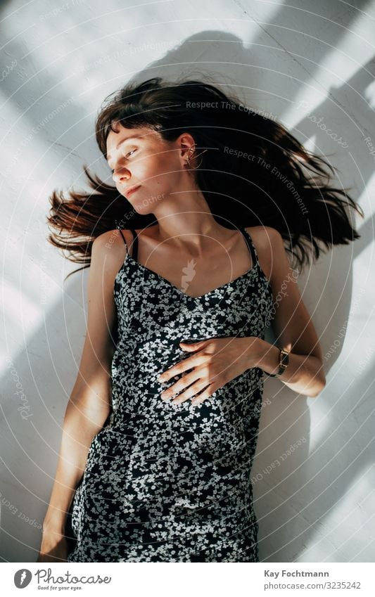 beautiful brunette woman lying on the floor of her apartment to relax Woman attractive beauty brown brown hair calm carefree casual caucasian coolness dreamy