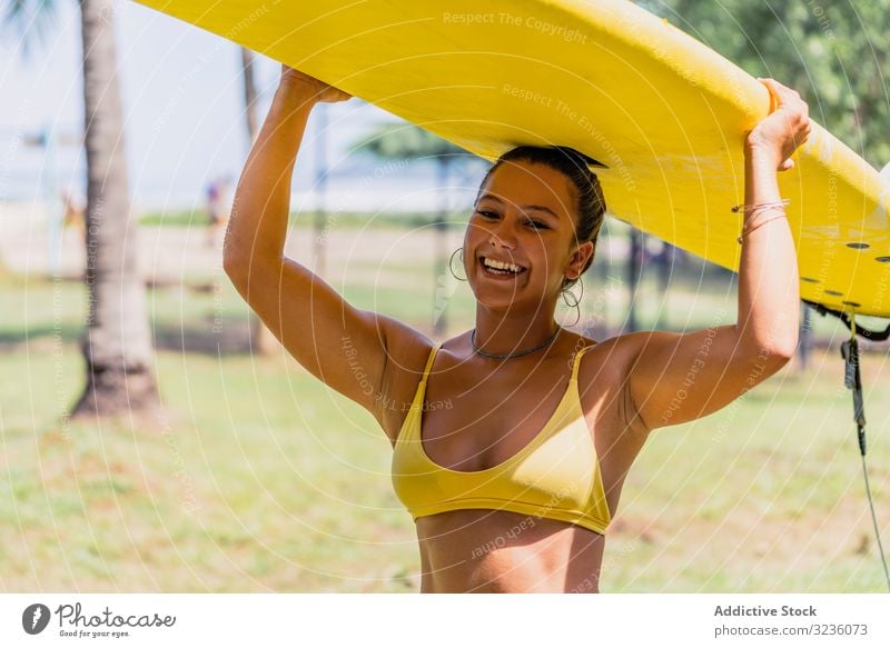 Woman in bikini with bright paddleboard on beach woman seashore palm tree fit tanned swimsuit sunny smile positive costa rica yellow young adult ocean summer