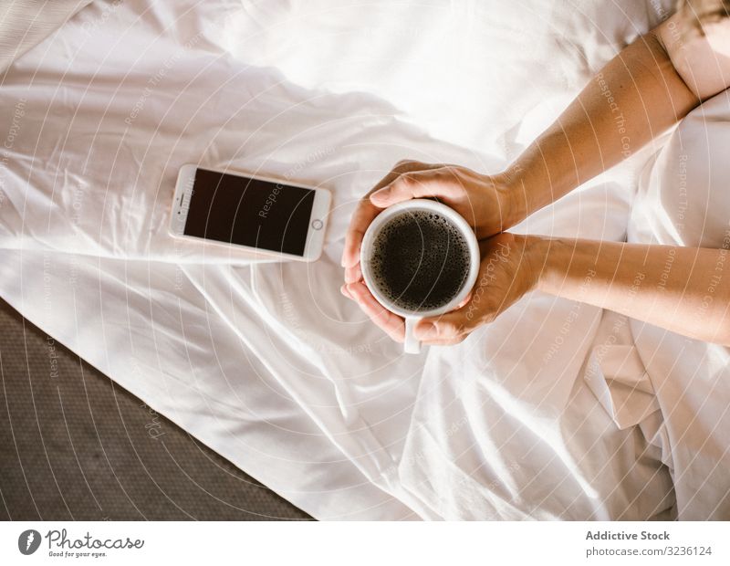 Woman having hot drink and using smartphone in bed coffee use woman message home text information check focus share browsing blank screen surfing social media