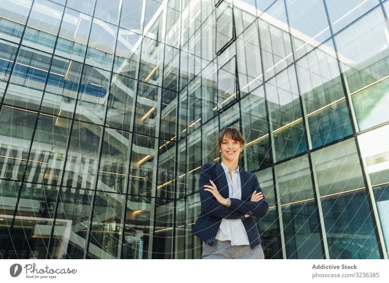 Confident businesswoman outside modern building confident street city smile crossed arms adult female elegant casual folded positive urban town contemporary