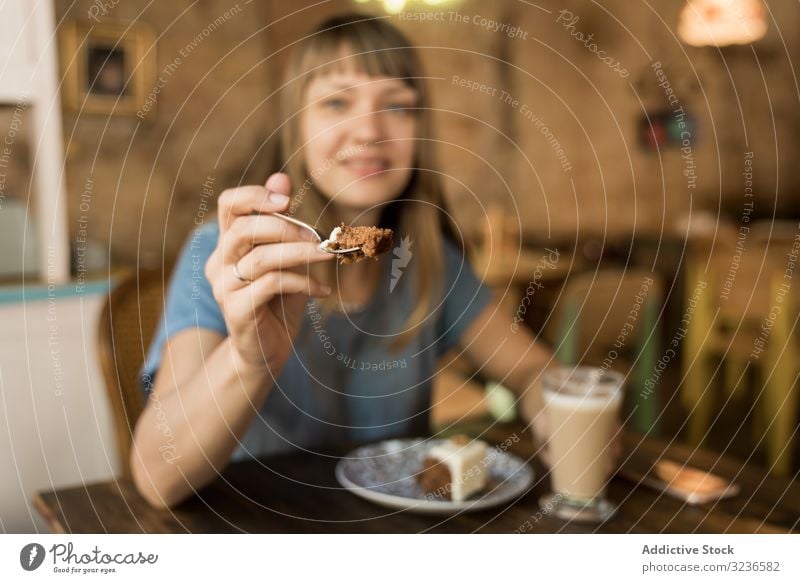 Woman holding spoon with slice of cake woman cafe giving piece coffee lifestyle young happy offer female tasty cheerful leisure drink casual try restaurant