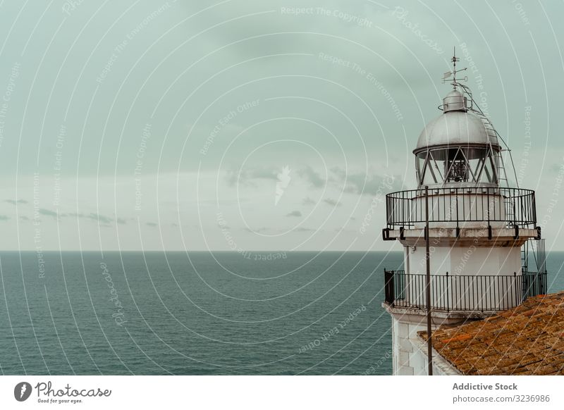 White lighthouse on sea shore building coast roof tile water ocean tower architecture beacon nature coastline destination white seascape navigation harbor