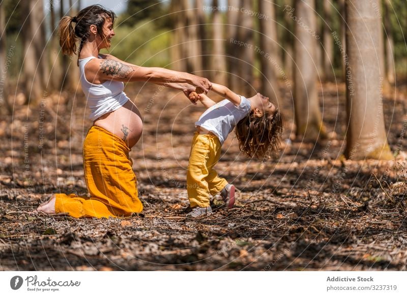 Pregnant mother and little daughter having fun in park belly love pregnant bonding compare parent cheerful happy prenatal maternity challenge motherhood