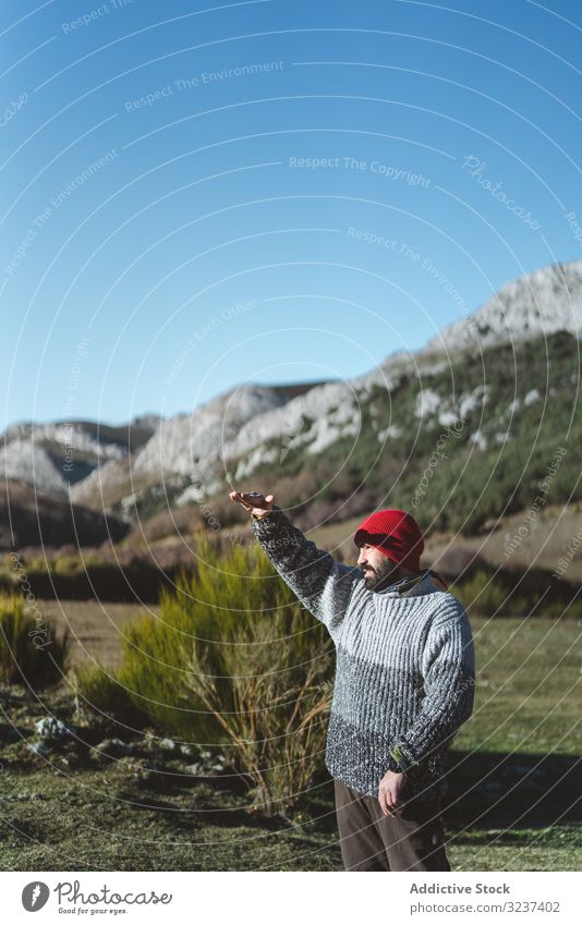 Man standing on valley and looking into distance man mountain traveler adult tourist adventure activity trekking backpacker hiker extreme male beard cap