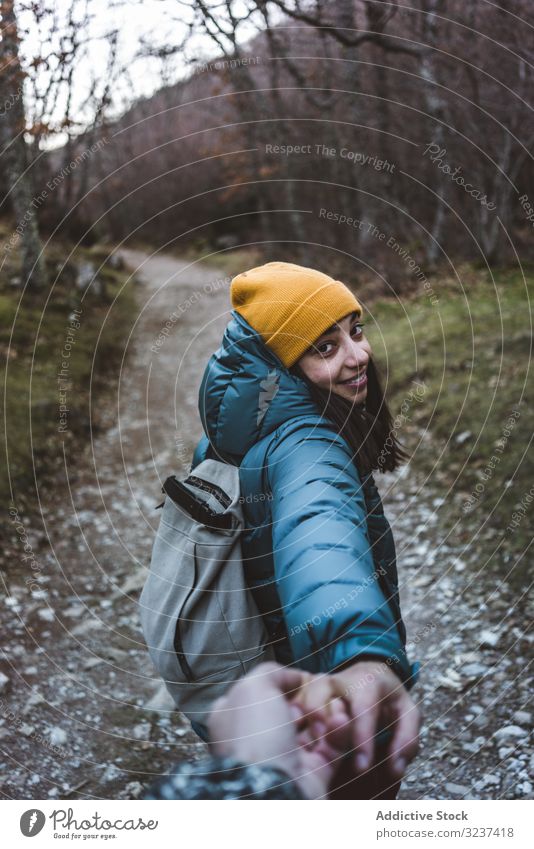 Teen girl with followed person trekking on forest trail autumn follow me invite teen traveler backpack hands teenager tree trekker season adventure trip