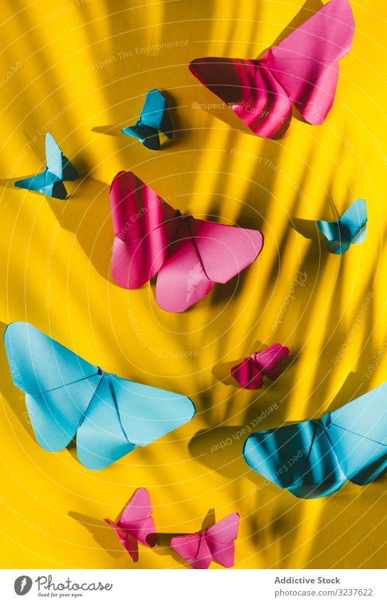 Paper butterflies on yellow cardboard butterfly decor paper carved handmade home shape composition art bright vivid vibrant origami paper craft creative hang