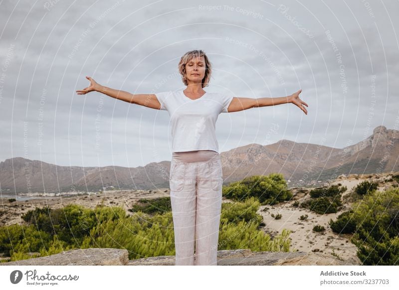 Barefoot woman meditating on stone meditation exercise rock tai chi closed eyes nature sky cloudy training female adult barefoot breath healthy fit yoga