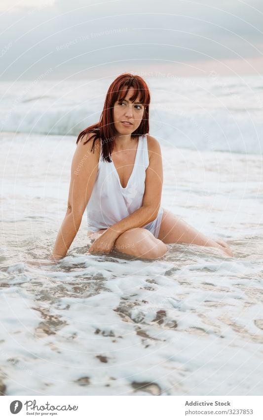 Ginger woman relaxing on beach during sunset sea redhead ginger relaxed sensual free dreaming peaceful seductive elegance body figure female ocean waves