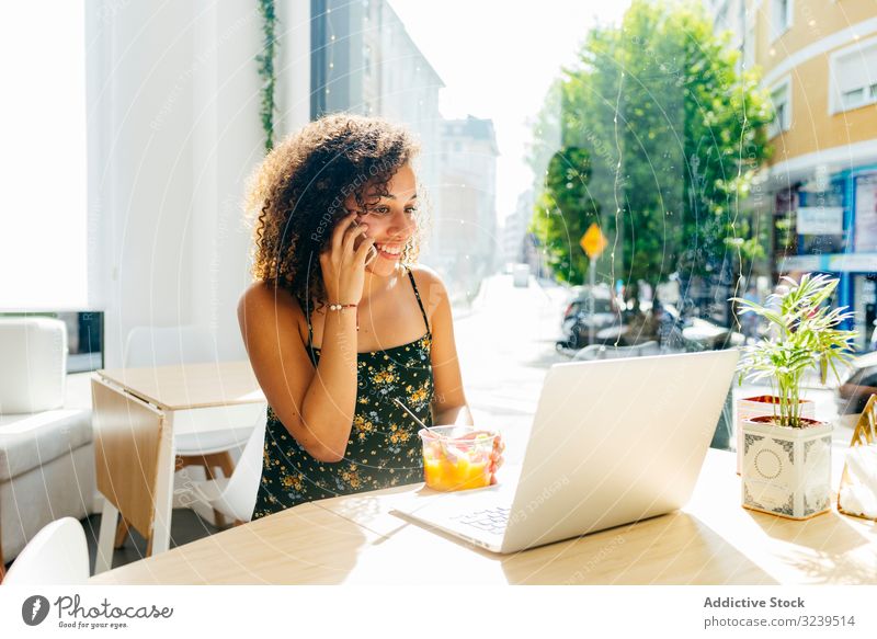 Ethnic female with laptop enjoying healthy drink in cafe woman using juice ethnic table window sit lifestyle rest relax glass smoothie detox beverage lady