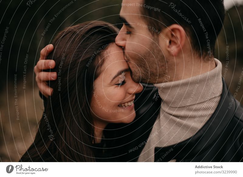 Happy couple hugging among pine forest coniferous love date happy passion glad relationship romance intimate smile pleasure caress embrace enjoy gentle