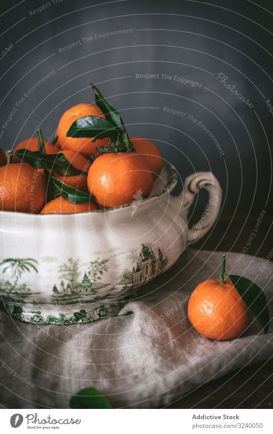 Orange tangerines in ceramic ornamental bowl on wooden table sophisticated fruit healthy classic composition still life art fresh juicy organic green tasty food