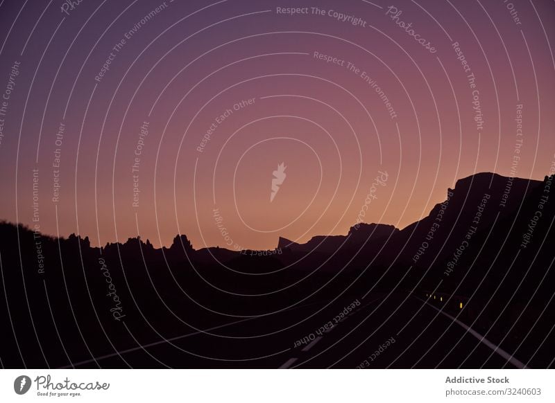View from car window of road and mountains at night outline el teide volcano tenerife island spain dawn silhouette travel transport vehicle nature drive trip