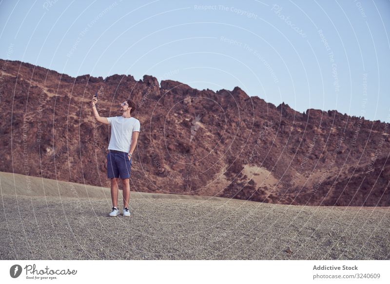 Man using cell phone in Teide, Spain man mountain volcano rocky island tourism tenerife spain el teide travel terrain explore male location hiker adventure