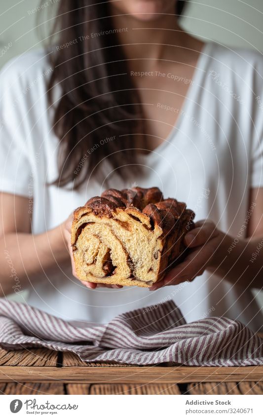 Faceless woman with appetizing cinnamon babka cook bread dessert baked twisted loaf delicious food sweet homemade fresh chocolate cuisine female white t shirt