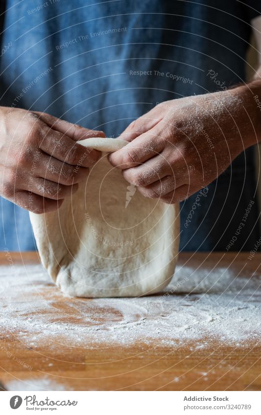 Crop man flattening dough for pizza flour soft fresh cuisine kitchen preparation food chef italian traditional male apron raw uncooked pizzeria cafe restaurant