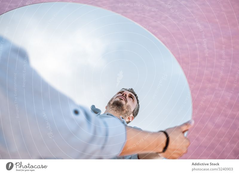 Stylish man holding mirror with reflection stylish pensive white shirt suspenders stand blue sky lifting carrying handsome oval surreal usa concept modern young