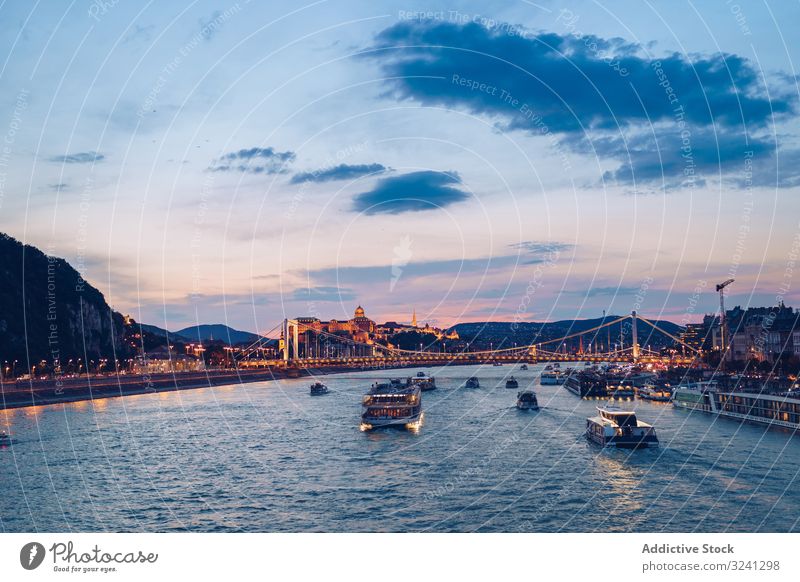 Evening river landscape under cloudy sky with illuminated city channel illumination evening flow reflection tourist twilight tourism dusk sightseeing structure