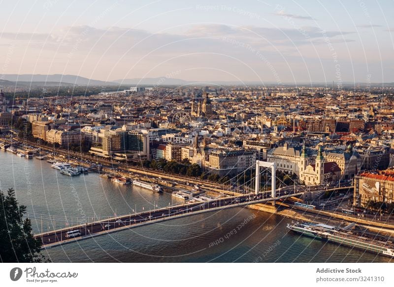 Boats on city channel flowing under bridge in bright day cityscape sky calm architecture landscape scenic aerial drone view budapest nature stream urban