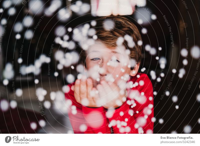 young boy blowing artificial snow flakes at home. Christmas Lifestyle Joy Beautiful Playing Winter Snow House (Residential Structure) Child Masculine