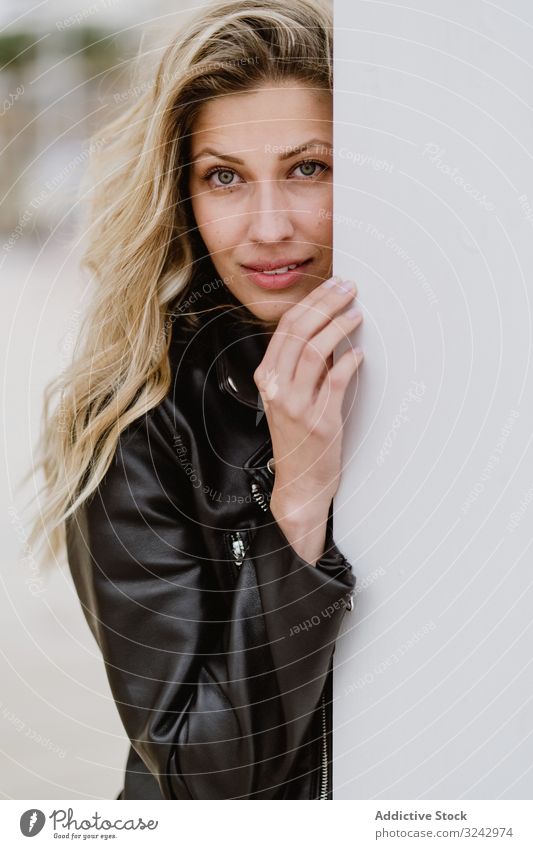 Charming tender woman standing behind white wall romantic style hide stylish pensive from behind natural long hair trendy curly female cool urban confident