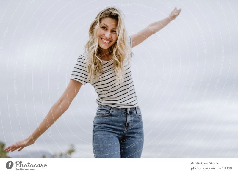 Happy woman walking with spread arms happy joyful enjoy fun casual young female laugh smile excited beautiful leisure carefree attractive modern cheerful street