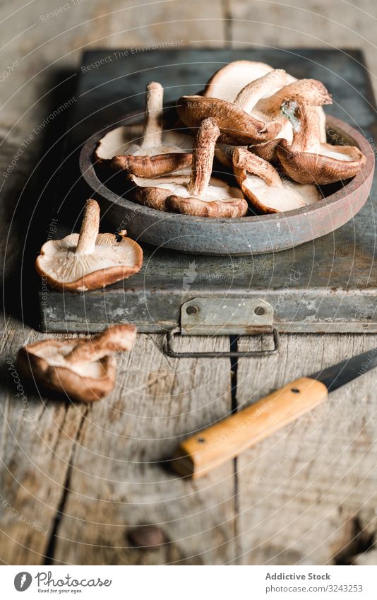 Pile of fresh brown mushrooms on rustic wooden table ingredient knife cuisine cooking nutrition shiitake food meal cultivated metallic fungi botany plant wild