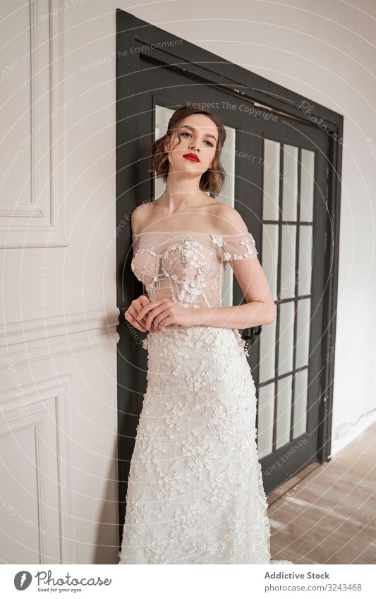 Magnificent pensive young bride in white lace dress looking at camera and pondering woman wedding dress vogue red lips elegant dream romantic chic couture