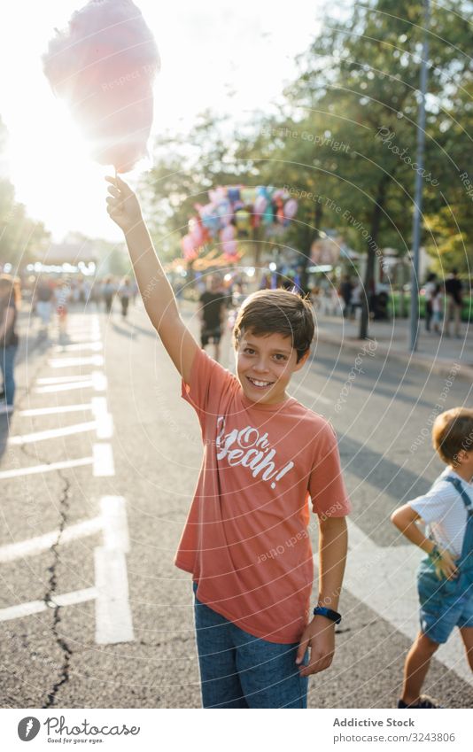 Cheerful kids enjoying sweet candyfloss on street children fun eat sibling bite fair city brother together boy girl friend casual town summer urban delicious