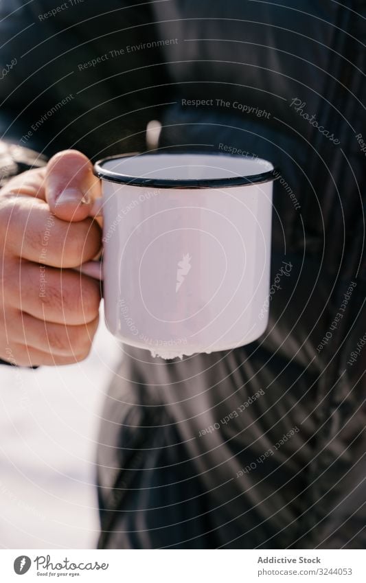 Traveler with enamel mug of tea on winter day man cold warm up siberia russia male hot break rest recreation drink relax adventure activity tourism travel