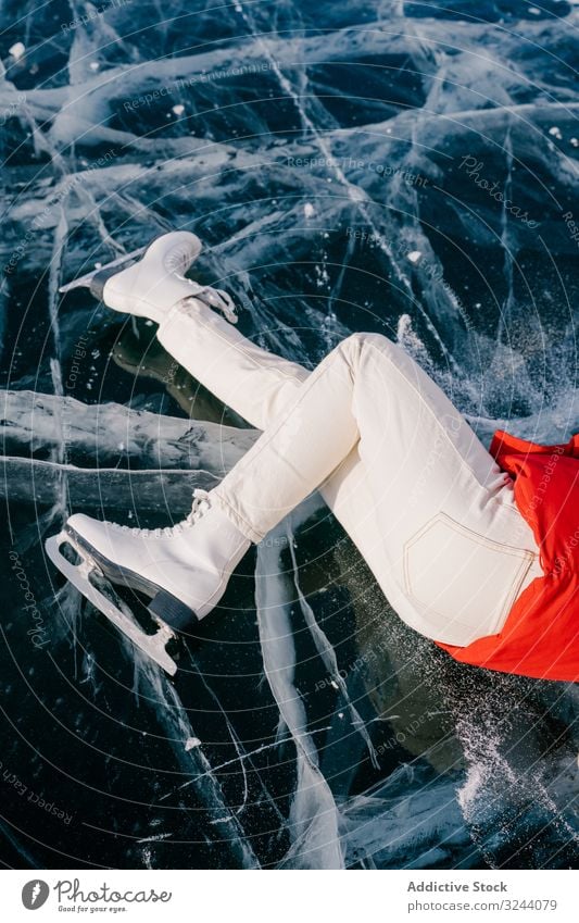 Happy woman in skates lying on ice happy enjoy winter river frozen siberia nature freedom cold russia female young fun adventure activity tourism travel journey