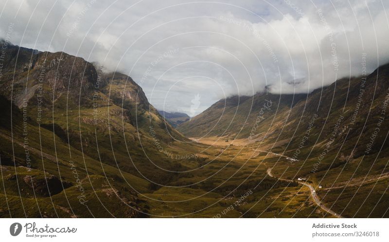 Wonderful scenery of highland under lush dramatic clouds valley mountain road sky hill height ridge horizon tranquil fresh wild river idyllic overview scotland