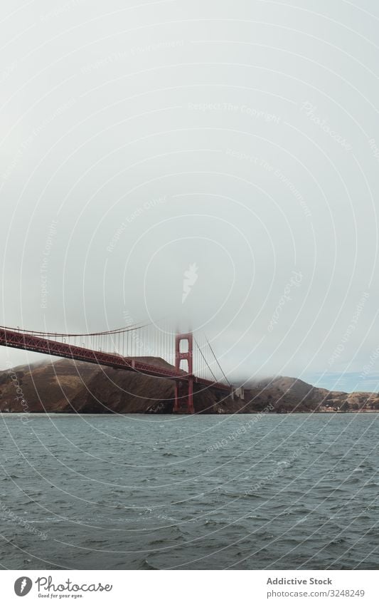 Red bridge construction over wavy dark water shore structure architecture rocky landscape stone sea mountain ocean travel island nature golden gate