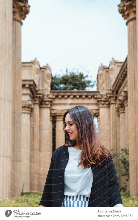 Active woman walking between ancient columns of building outside geometric architecture park support female adult design travel street san francisco vacation