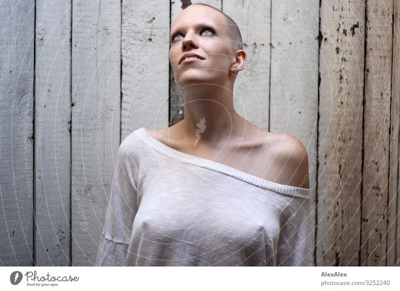 Woman with very short hair looks smiling at skylight in front of board wall Style pretty Attic Wooden wall Young woman Youth (Young adults) 18 - 30 years Adults