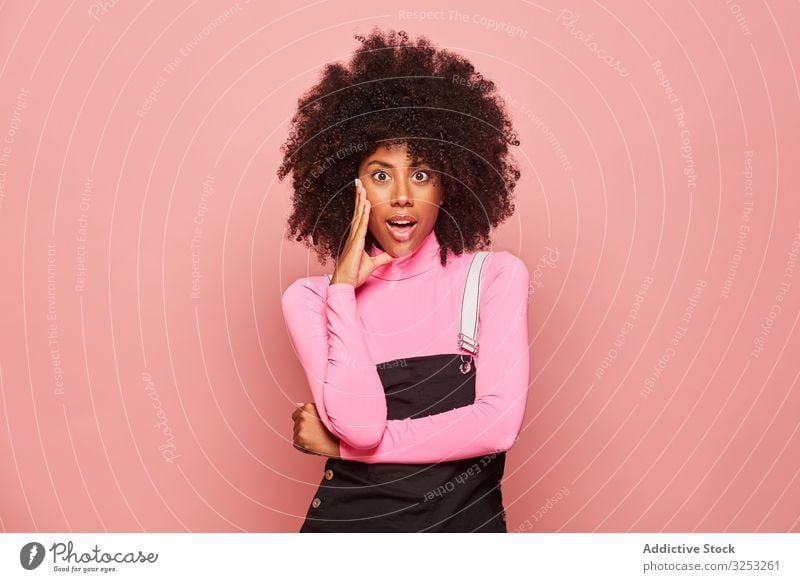 Shocked African American woman looking at camera surprised amazed shocked young casual pink african american black stand female ethnic turtleneck overall