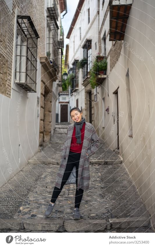 Joyful female tourist in casual wear amid city street woman travel walk explore smile lane enjoy young holiday lifestyle adventure vacation albaicin granada