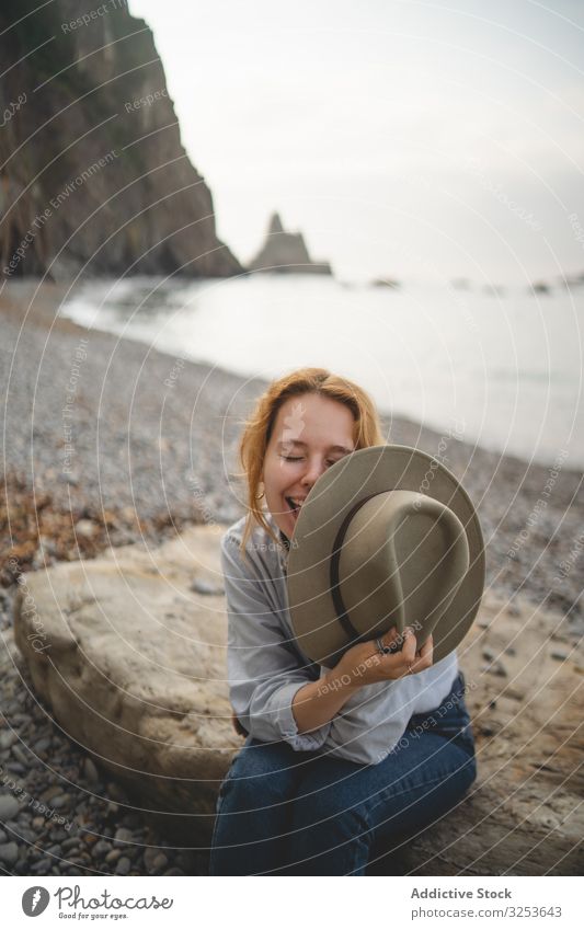 Woman resting on beach stone by sea woman bay water seascape coast shore rock calm contemplate dreaming carefree tourist enjoy relax chill traveler distance