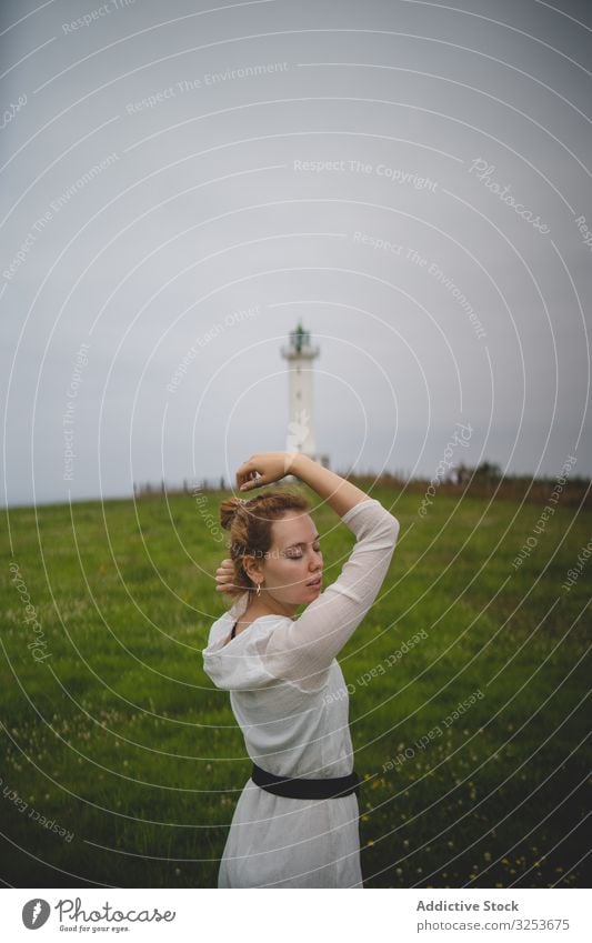 Woman walking in green meadow near lighthouse woman field tender peaceful gentle thoughtful calm redhead ginger scenic nature asturias spain europe sensual