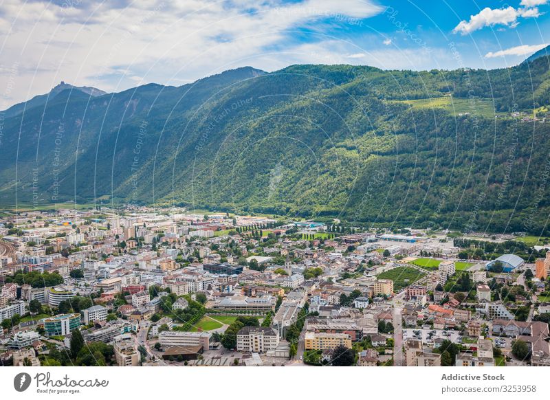 Densely populated town at foot of green mountains valley idyllic remote range small rocky landscape ridge stone architecture travel island structure nature road