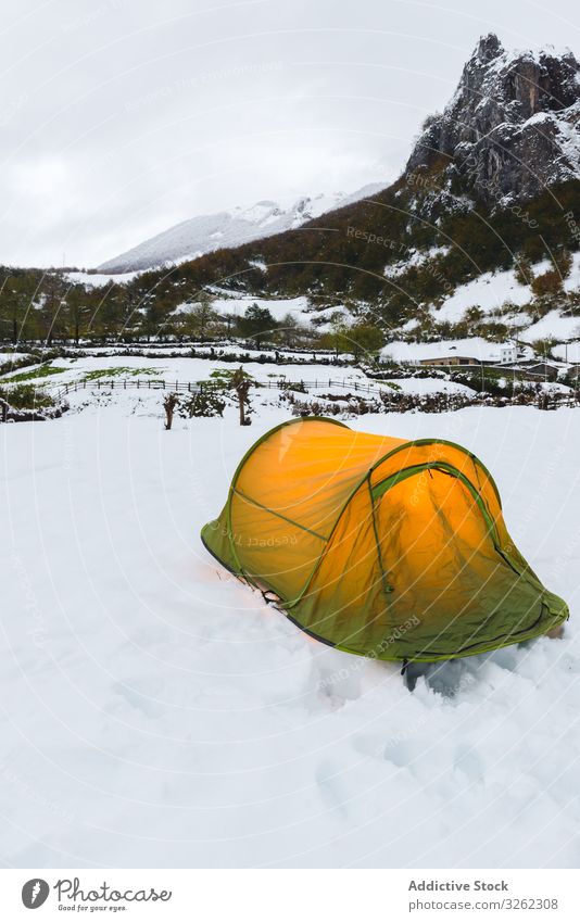 Tourist tent in mountains on snow tourism forest adventure travel nature landscape camp winter hiking cold trekking activity explore hill climb green light