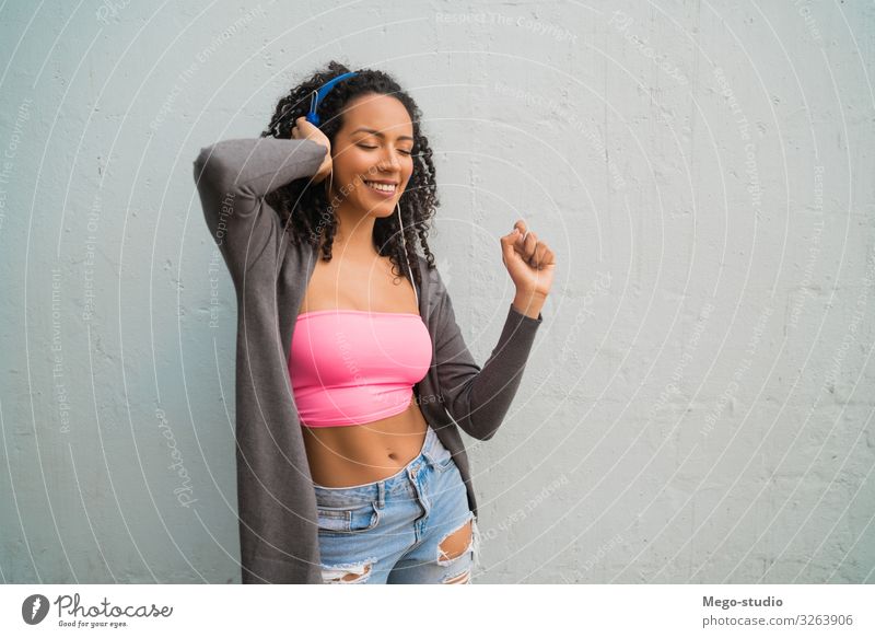 Young afro woman listening to music with headphones. Lifestyle Style Joy Happy Beautiful Music Woman Adults Afro To enjoy Listening Smiling Stand Happiness Cute