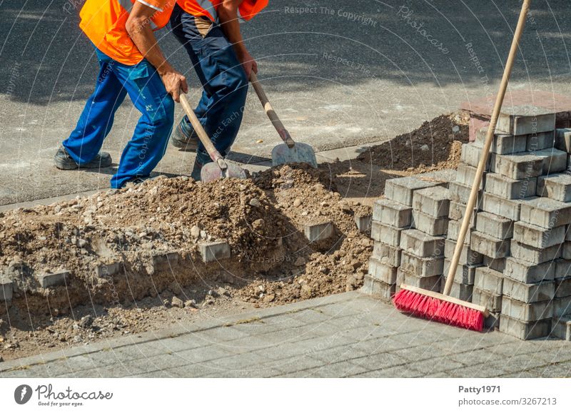 Two construction workers push sand into a construction pit together - teamwork concept Work and employment Profession Construction worker Construction site