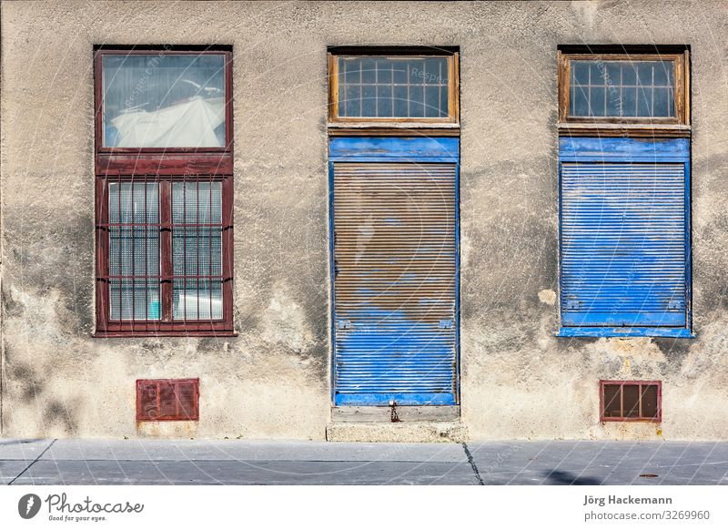 closed door with closed windows at a dirty house facade in Facade Esthetic abandoned blue locked old rot Rust shutter Symbols and metaphors time vienna wreck