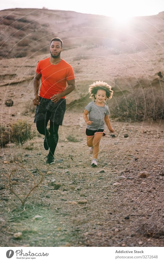 Black man jogging with toddler on nature child run together sport active healthcare father parent smile desert morning lifestyle support dynamic diverse